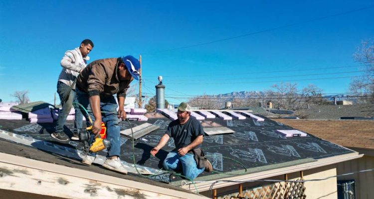 Active Roofing Installation Workers engaged in installing a new roof, demonstrating teamwork and the use of professional roofing techniques.