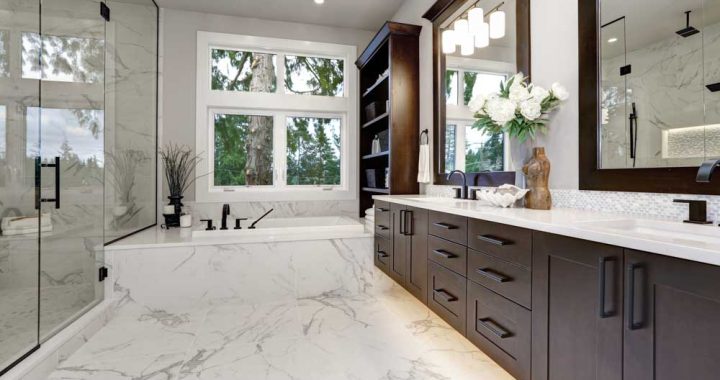 Luxurious Marble Bathroom Interior Elegant bathroom featuring extensive marble detailing, a freestanding bathtub, dark wooden vanities, and a view of greenery outside the window.