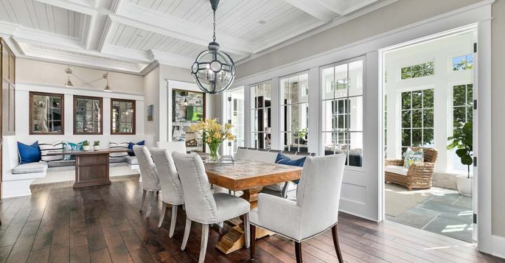Elegant yet informal dining area of new home with coffered ceiling Informal bench dining and spacious area next to bright and cheery sunroom